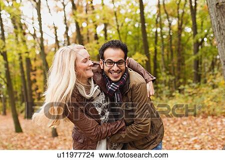 Smiling couple hugging in forest View Large Photo Image Picture - Smiling couple hugging in forest. Fotosearch
