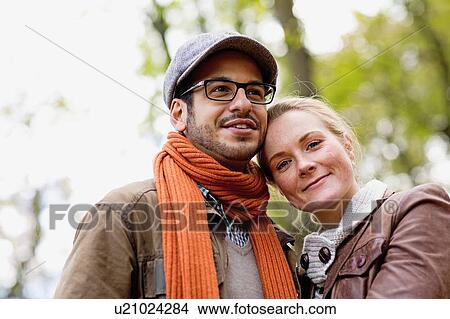 Picture - Smiling couple hugging in forest. Fotosearch