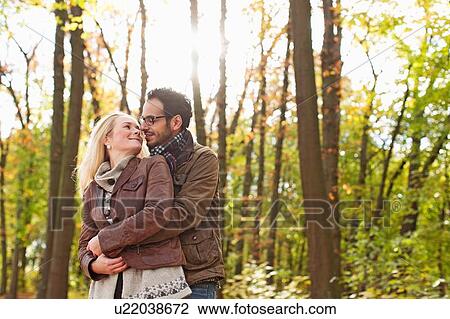 Smiling couple hugging in forest View Large Photo Image Stock Image - Smiling couple hugging in forest. Fotosearch