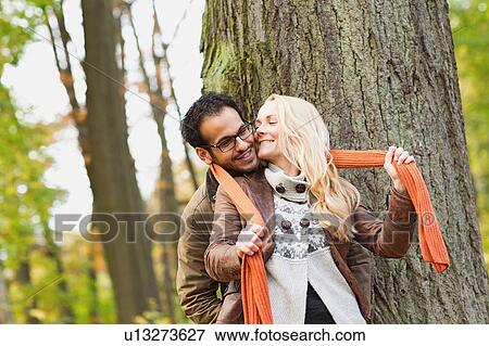 Stock Photo - Smiling couple hugging in forest. Fotosearch