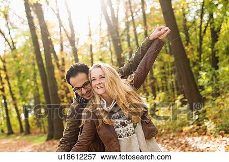 Stock Photo - Smiling couple hugging in forest. Fotosearch