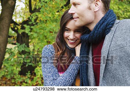 Smiling couple hugging in forest View Large Photo Image Stock Photo - Smiling couple hugging in forest. Fotosearch