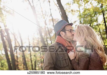 Smiling couple kissing in forest View Large Photo Image Stock Image - Smiling couple kissing in forest. Fotosearch