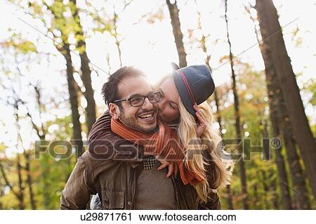 Smiling couple kissing in forest View Large Photo Image Stock Image - Smiling couple kissing in forest. Fotosearch