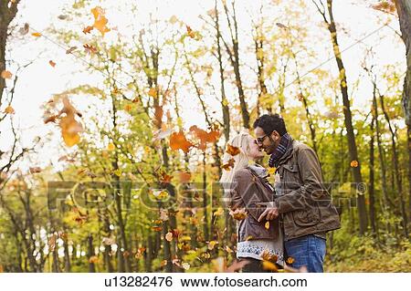 Smiling couple kissing in forest View Large Photo Image Stock Photograph - Smiling couple kissing in forest. Fotosearch