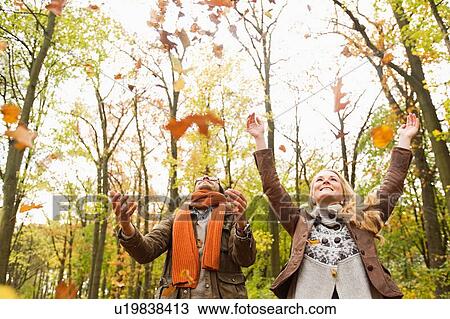 Smiling couple playing in autumn leaves View Large Photo Image Stock Image - Smiling couple playing in autumn leaves. Fotosearch