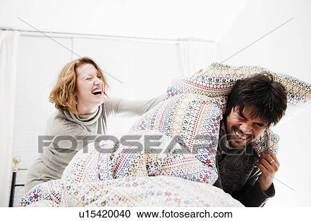 Smiling couple playing in bed View Large Photo Image Stock Image - Smiling couple playing in bed. Fotosearch