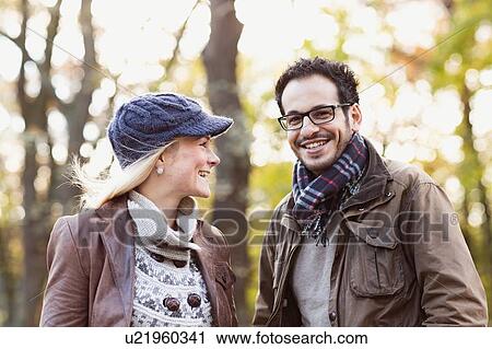 Smiling couple standing in forest View Large Photo Image Stock Image - Smiling couple standing in forest. Fotosearch