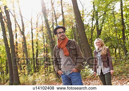 Stock Photo - Smiling couple standing in forest. Fotosearch