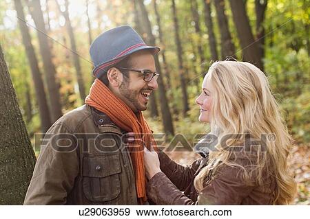 Stock Photo - Smiling couple talking in forest. Fotosearch
