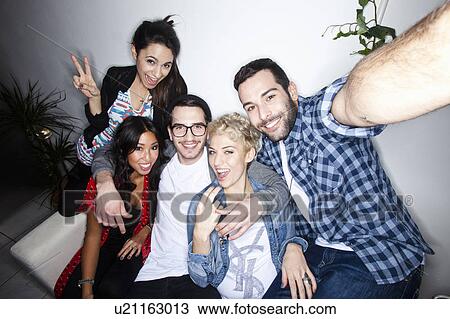 Smiling friends taking picture together View Large Photo Image Stock Image - Smiling friends taking picture together. Fotosearch