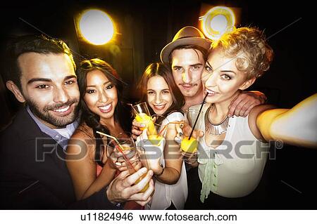 Stock Photograph - Smiling friends taking picture together. Fotosearch