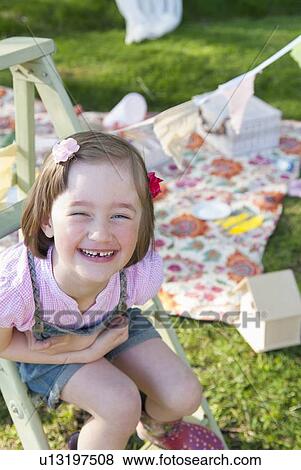 Smiling girl sitting on ladder outdoors View Large Photo Image Stock Photo - Smiling girl sitting on ladder outdoors. Fotosearch