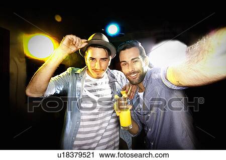 Stock Image - Smiling men taking picture together. Fotosearch