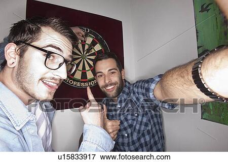 Stock Photo - Smiling men taking picture together. Fotosearch