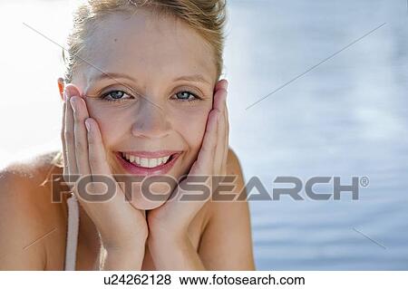 Stock Photo - Smiling woman cupping chin in hands. Fotosearch
