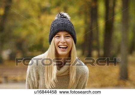 Stock Photo - Smiling woman laughing in forest. Fotosearch