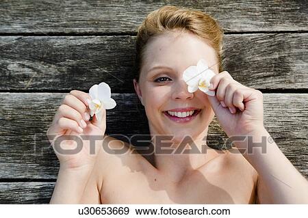 Smiling woman playing with flowers View Large Photo Image Stock Photo - Smiling woman playing with flowers. Fotosearch