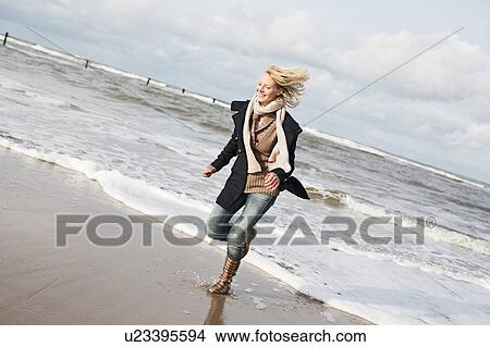 Smiling woman running on beach View Large Photo Image Picture - Smiling woman running on beach. Fotosearch