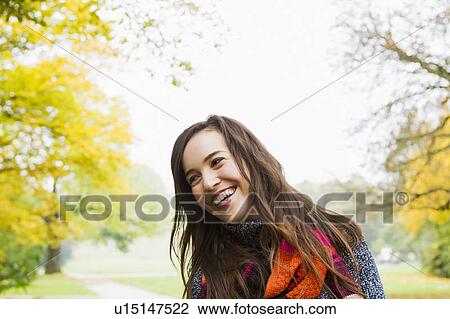 Stock Image - Smiling woman standing in forest. Fotosearch
