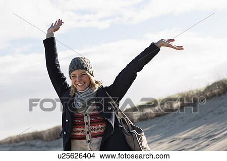 Smiling woman standing on beach View Large Photo Image Picture - Smiling woman standing on beach. Fotosearch