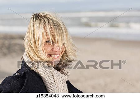 Smiling woman standing on beach View Large Photo Image Stock Image - Smiling woman standing on beach. Fotosearch