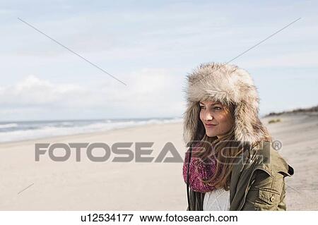 Smiling woman standing on beach View Large Photo Image Stock Photo - Smiling woman standing on beach. Fotosearch