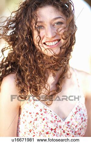 Stock Image - Smiling woman standing outdoors. Fotosearch