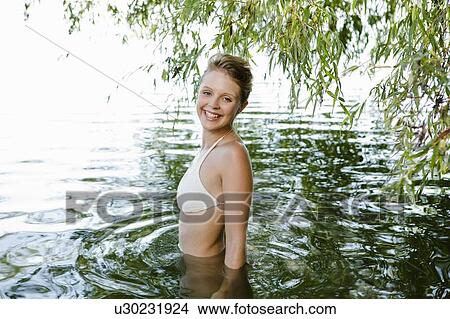 Smiling woman wading in river View Large Photo Image Picture - Smiling woman wading in river. Fotosearch