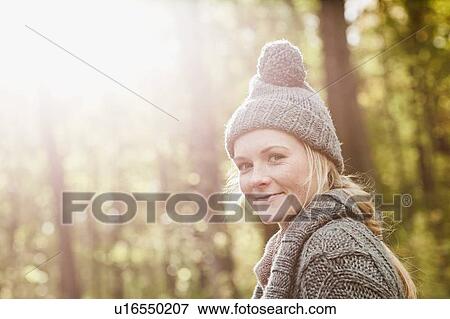 Stock Photo - Smiling woman walking in forest. Fotosearch