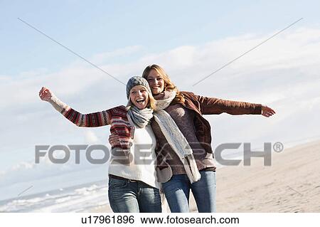 Smiling women hugging on beach View Large Photo Image Stock Photograph - Smiling women hugging on beach. Fotosearch