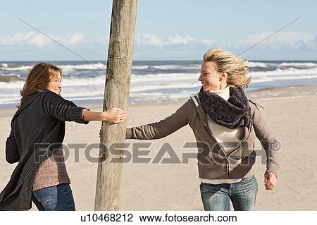 Smiling women playing on beach View Large Photo Image Stock Image - Smiling women playing on beach. Fotosearch