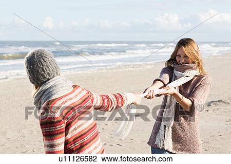 Smiling women playing on beach View Large Photo Image Stock Image - Smiling women playing on beach. Fotosearch