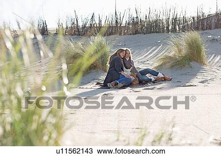 Smiling women relaxing on beach View Large Photo Image Stock Image - Smiling women relaxing on beach. Fotosearch