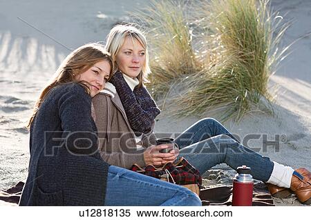Smiling women relaxing on beach View Large Photo Image Stock Photography - Smiling women relaxing on beach. Fotosearch
