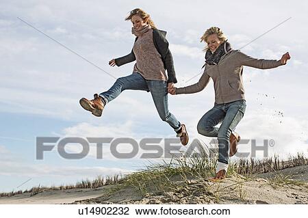 Smiling women running on beach View Large Photo Image Stock Image - Smiling women running on beach. Fotosearch