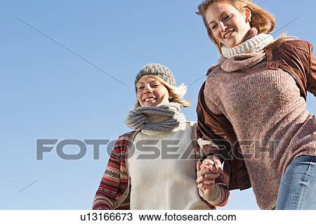 Stock Image - Smiling women running outdoors. Fotosearch