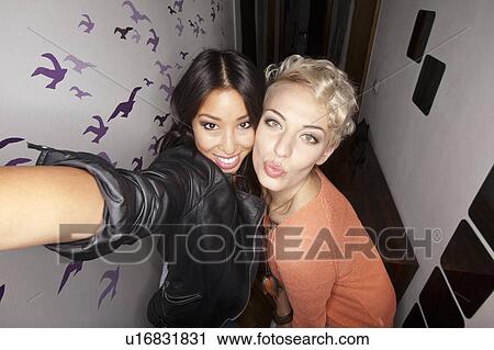 Smiling women taking picture together View Large Photo Image Stock Image - Smiling women taking picture together. Fotosearch