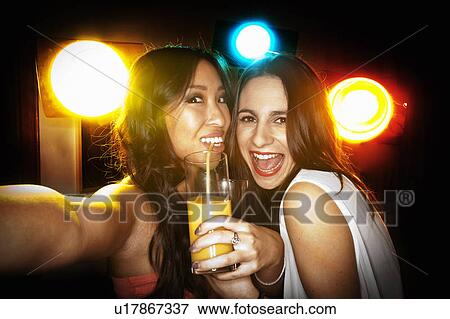 Smiling women taking picture together View Large Photo Image Stock Photo - Smiling women taking picture together. Fotosearch