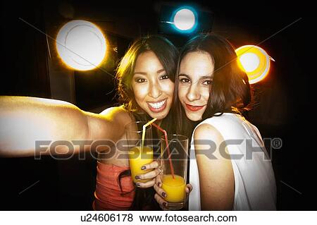 Smiling women taking picture together View Large Photo Image Stock Photo - Smiling women taking picture together. Fotosearch