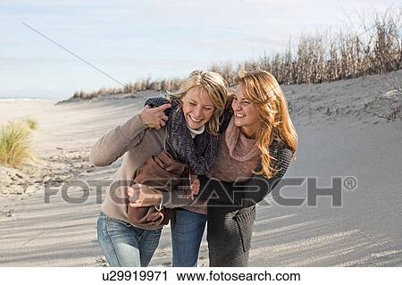 Smiling women walking on beach View Large Photo Image Stock Image - Smiling women walking on beach. Fotosearch