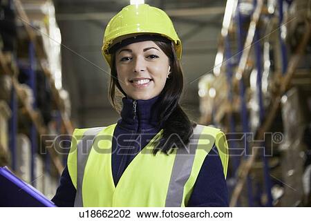 Smiling worker standing in warehouse View Large Photo Image Stock Image - Smiling worker standing in warehouse. Fotosearch