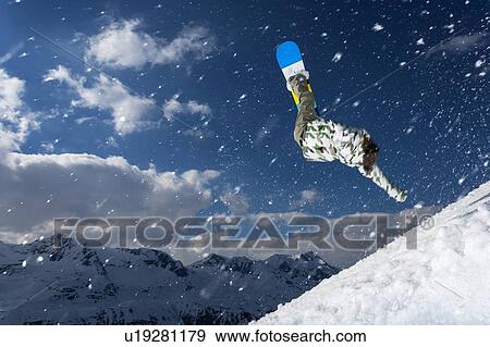 Snowboarder jumping on snowy slope View Large Photo Image Stock Photo - Snowboarder jumping on snowy slope. Fotosearch