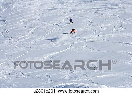 Stock Image - Snowboarders making tracks in snow. Fotosearch