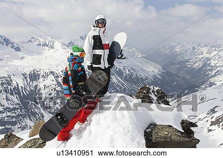 Snowboarders on rocky mountaintop View Large Photo Image Stock Image - Snowboarders on rocky mountaintop. Fotosearch