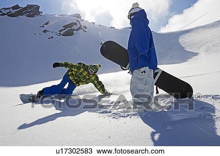 Stock Image - Snowboarders on snowy slope. Fotosearch