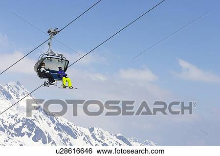 Snowboarders riding chair lift View Large Photo Image Stock Photograph - Snowboarders riding chair lift. Fotosearch