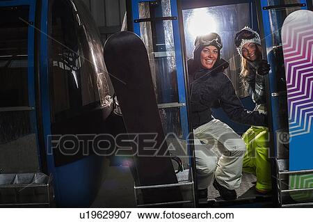 Stock Photo - Snowboarders riding in cable car. Fotosearch