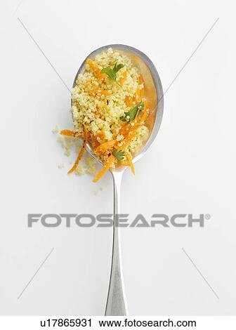 Stock Image - Spoonful of couscous and herbs. Fotosearch