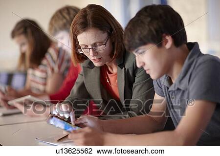 Student and teacher with tablet computer View Large Photo Image Stock Image - Student and teacher with tablet computer. Fotosearch